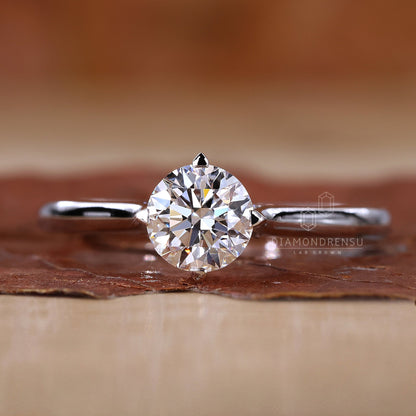 Round cut diamond solitaire engagement ring on a white background