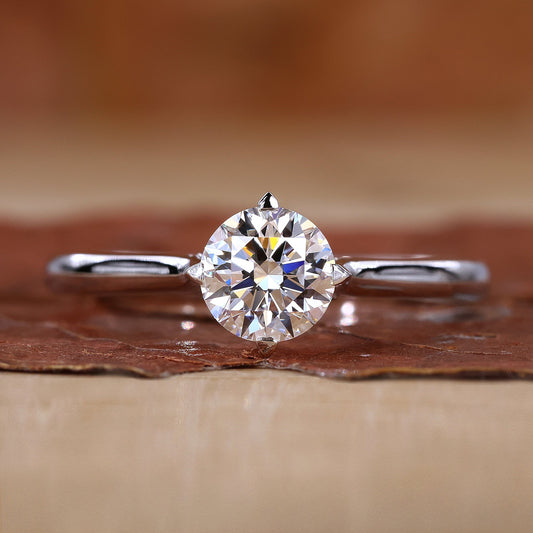 Close-up of round solitaire diamond ring with compass prongs setting