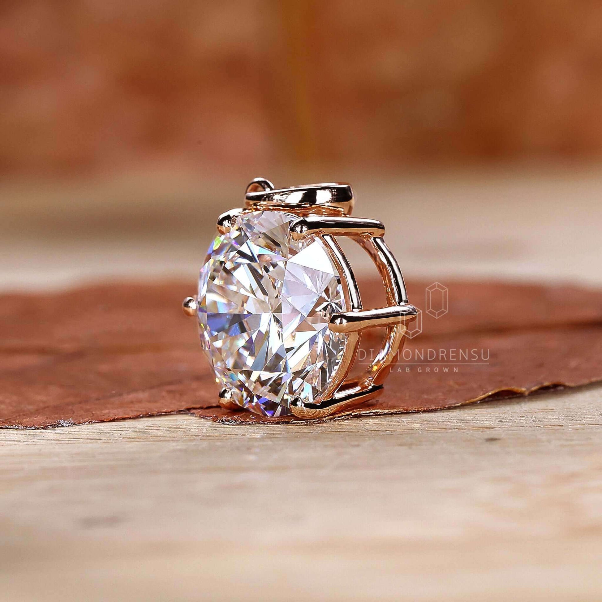 Basket setting solitaire diamond pendant highlighting the diamond's brilliance.