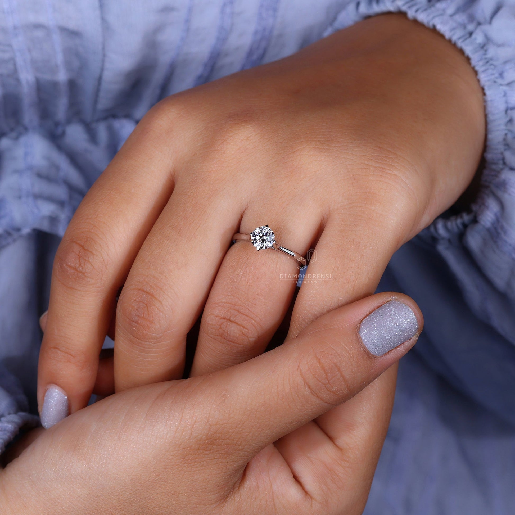 Model wearing round solitaire engagement ring with round cut diamond