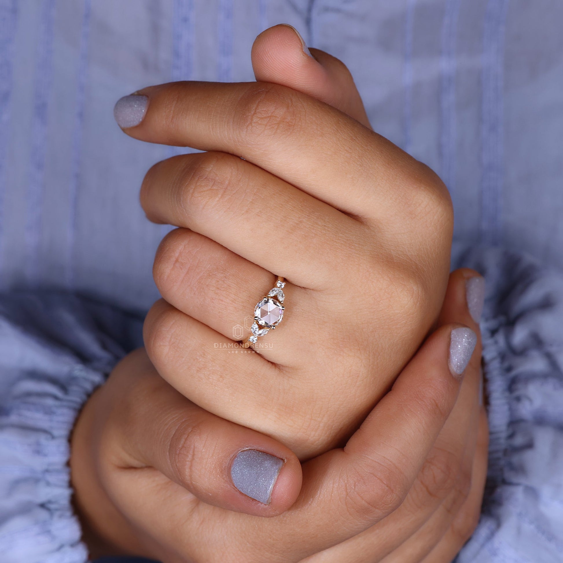 A close-up of a model's hand adorned with a stunning rose cut engagement ring.