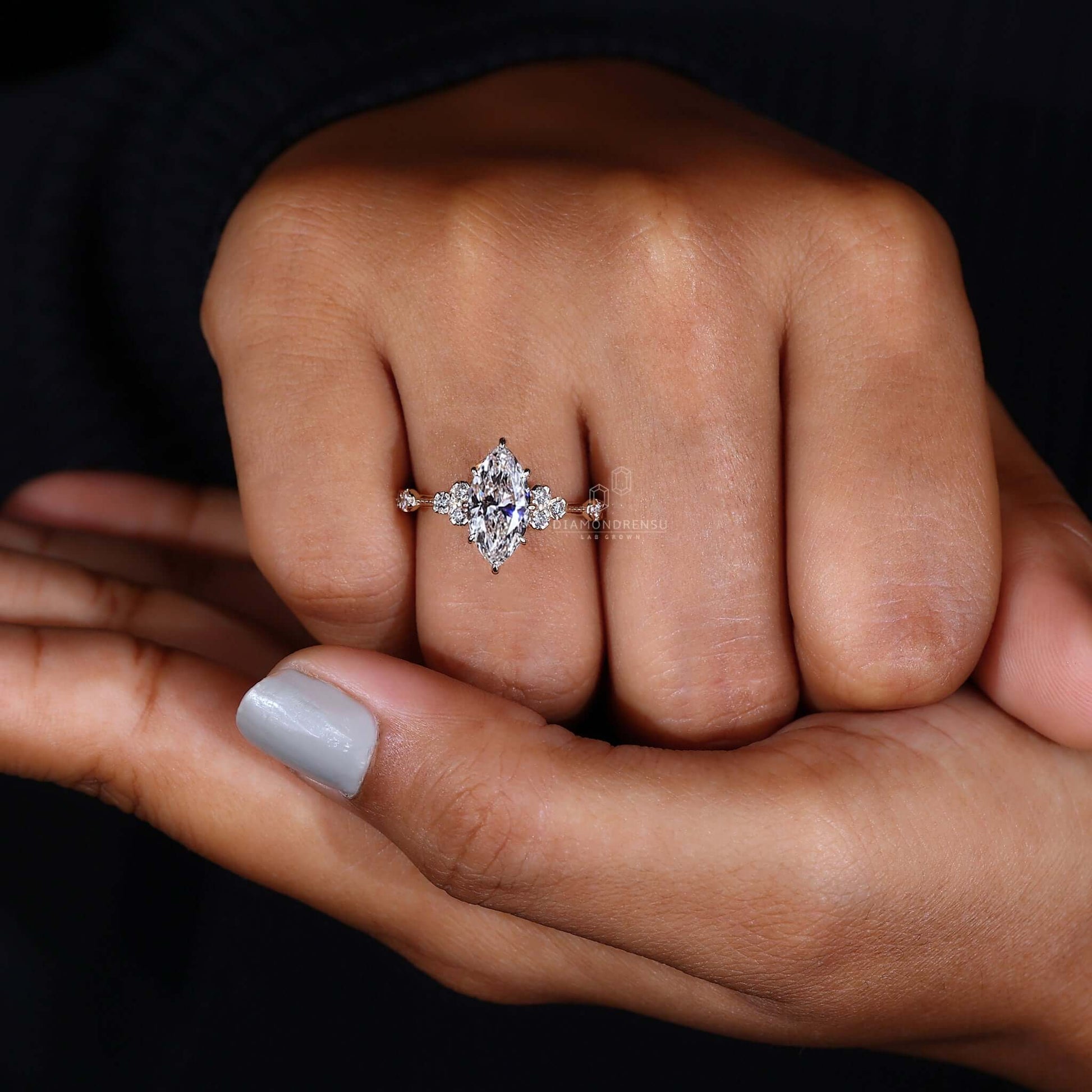 Hand gracefully presenting a marquise cut diamond ring, focusing on its distinct and luxurious appearance.