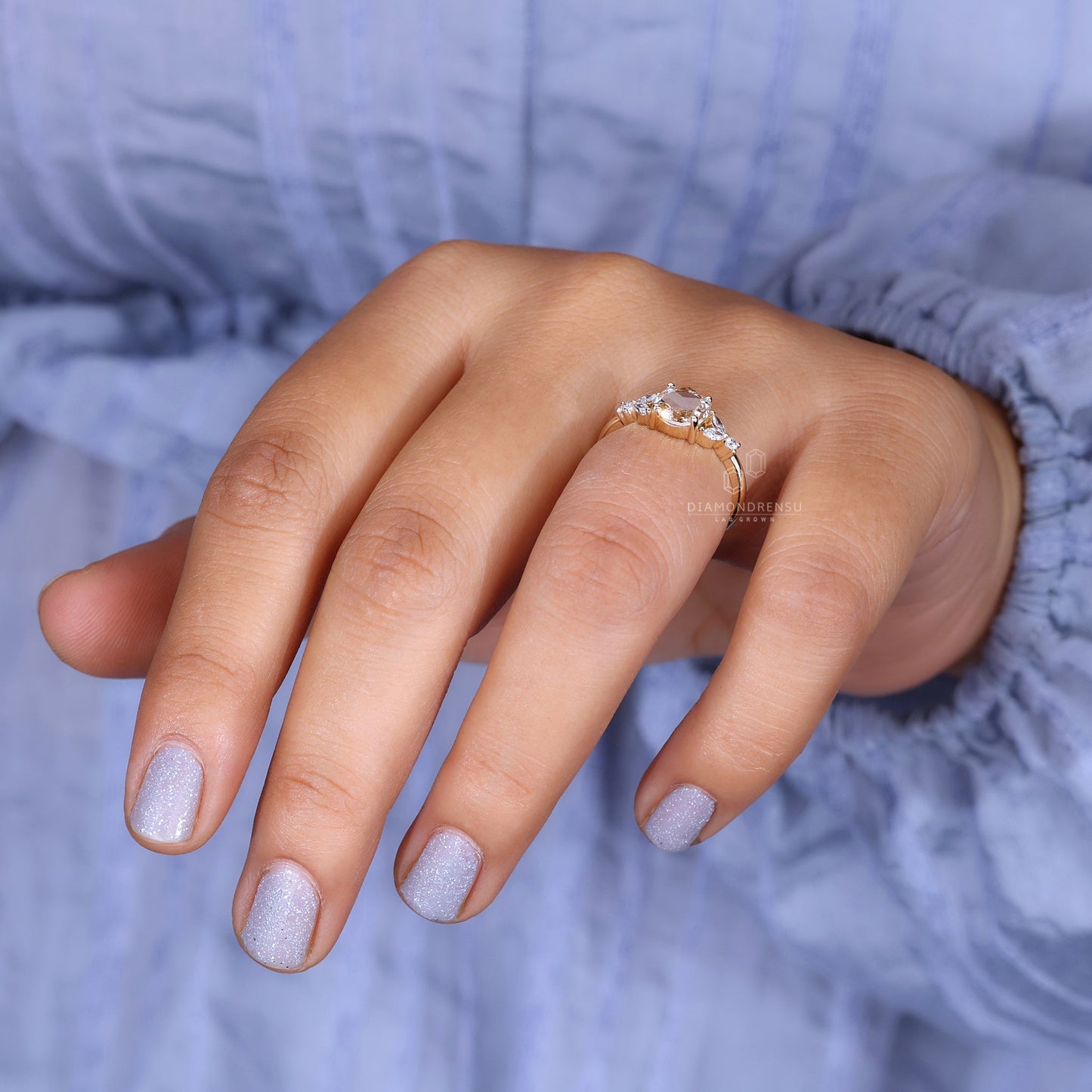 A model's hand featuring a round rose cut diamond engagement ring.