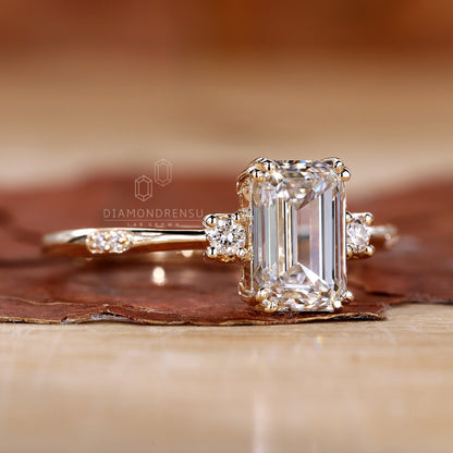 Man proposing with a three stone emerald cut ring at sunset