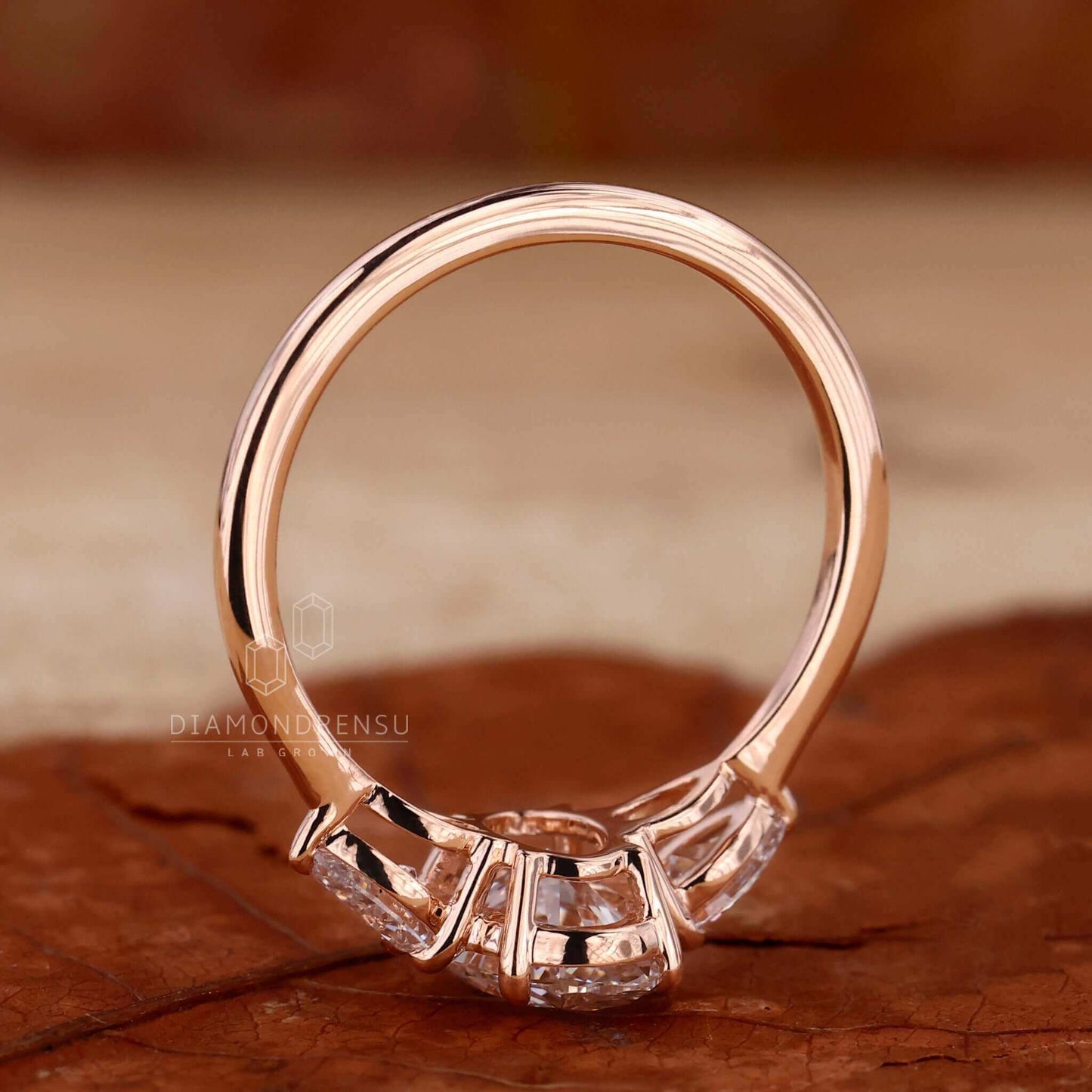 Detailed shot of an oval three stone engagement ring in a rose gold ring setting